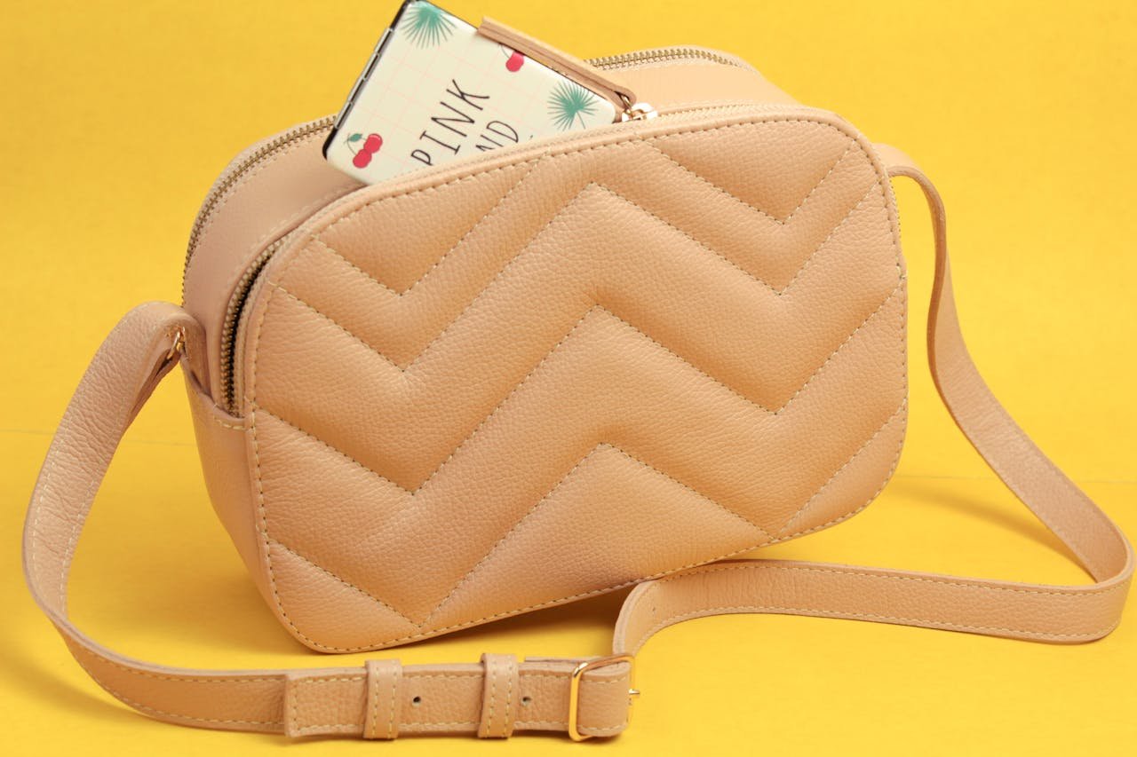 Elegant beige handbag on a vibrant yellow background, perfect for fashion themes.